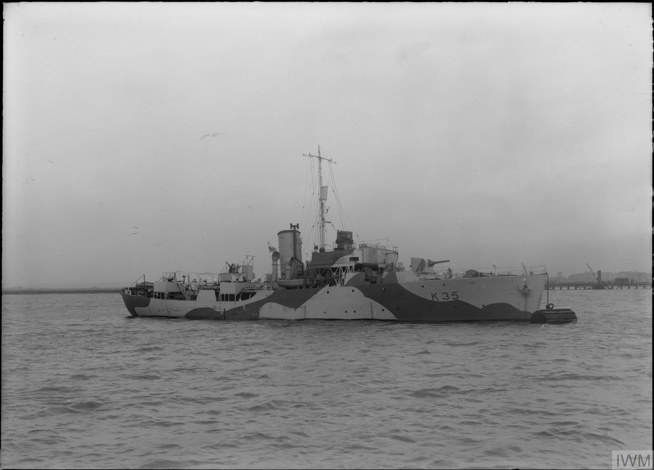 HMS Violet, a Flower-class corvette in disruptive camouflage, lying at a buoy